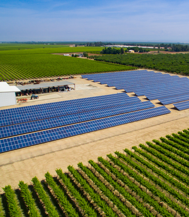 Overhead shot of a farm with open fields and solar panels.