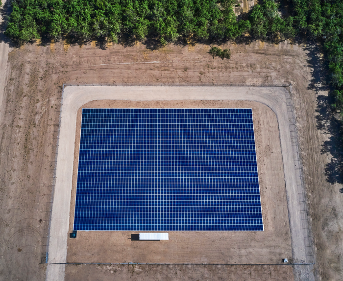 Birdseye view of a solar panels next to trees