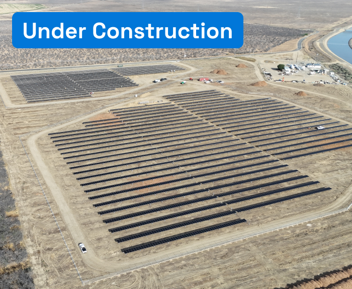Aerial view of a solar plant under construction on dry terrain.