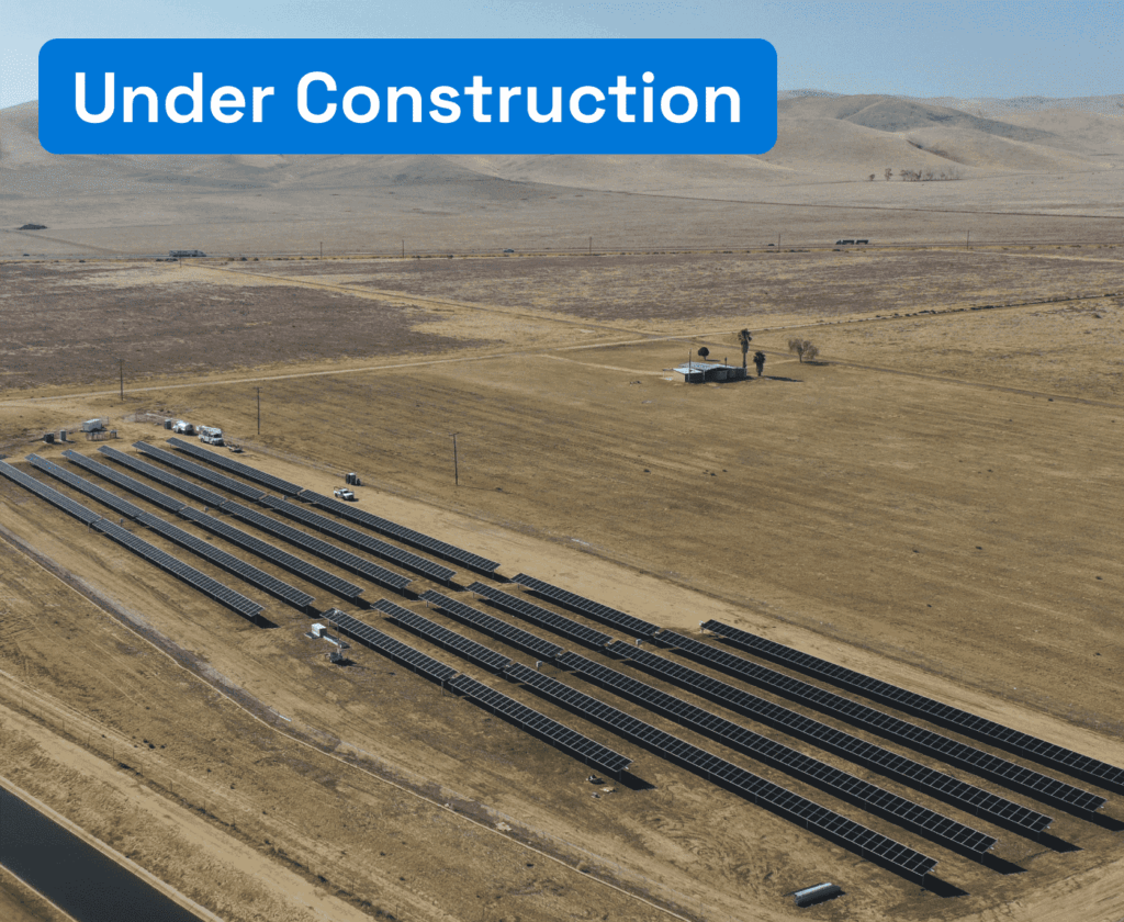 Aerial photo of solar panel plant on arid terrain.