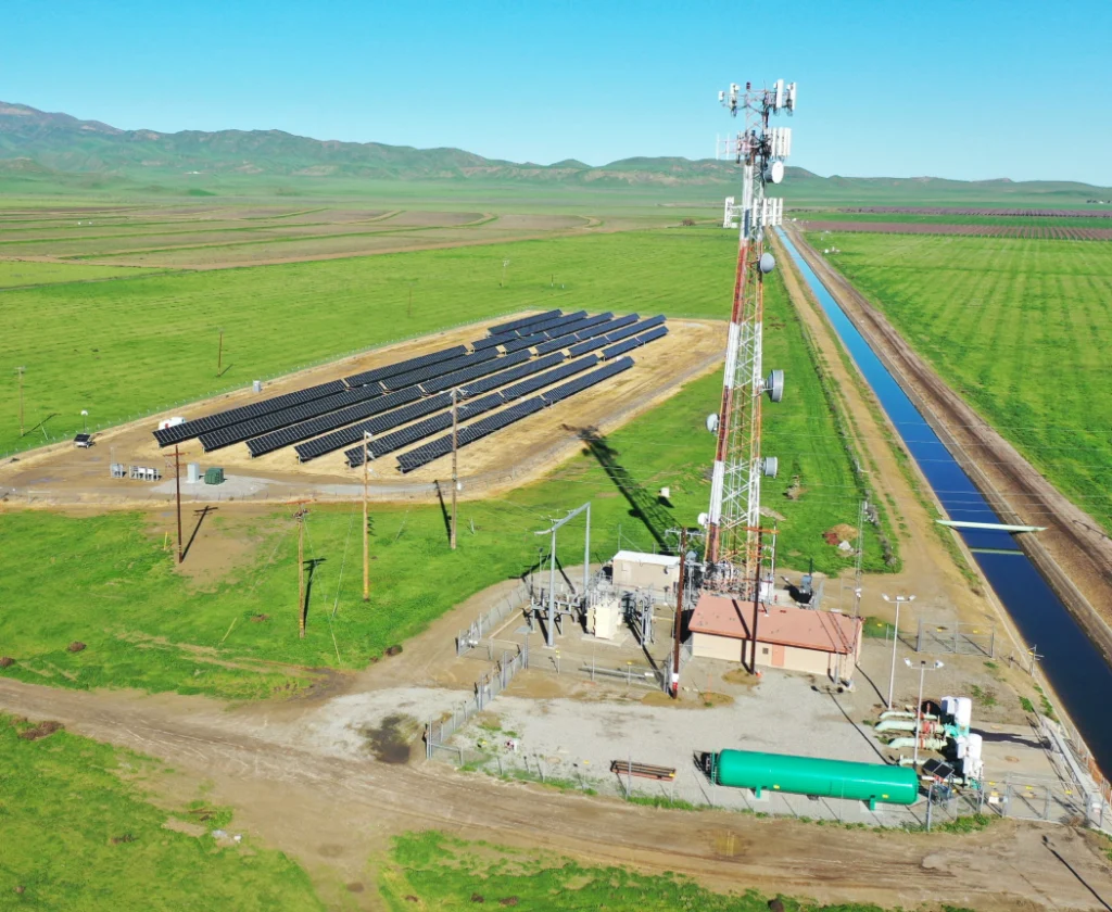 Aerial view of solar plant next to a communications tower.