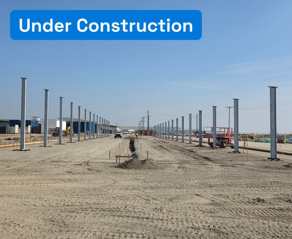 Bare construction ground with metal pillars.