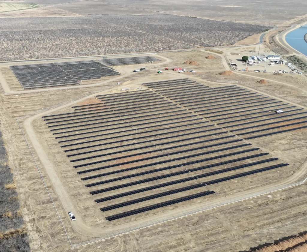 lost-hills-700x574 Aerial perspective of a ground-mounted solar panel field installed in a dry desert landscape.