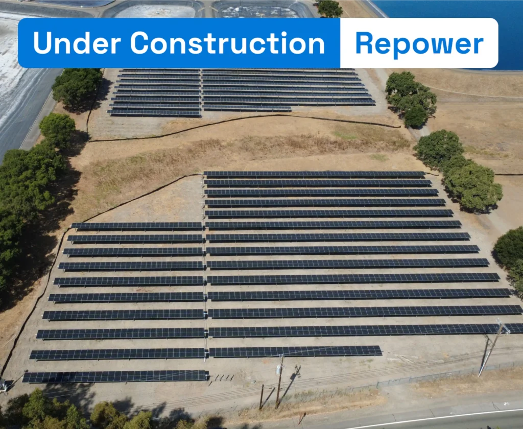Aerial view of a solar panel array repowering project under construction in Sonoma County next to water reservoirs.