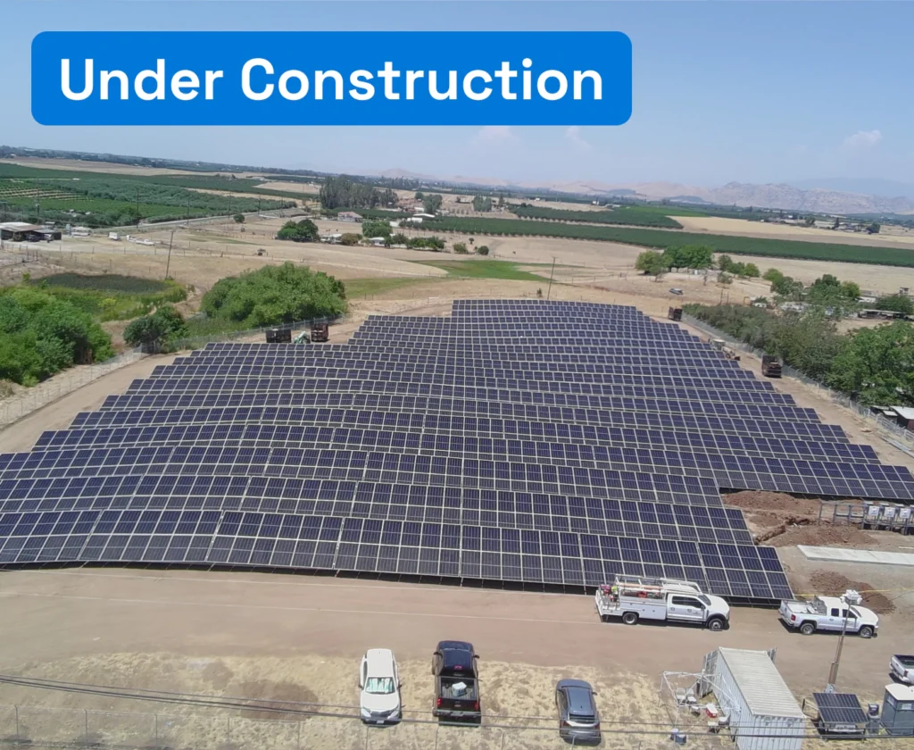 Aerial view of a solar panel array under construction at Terra Bella Irrigation District with work trucks nearby.