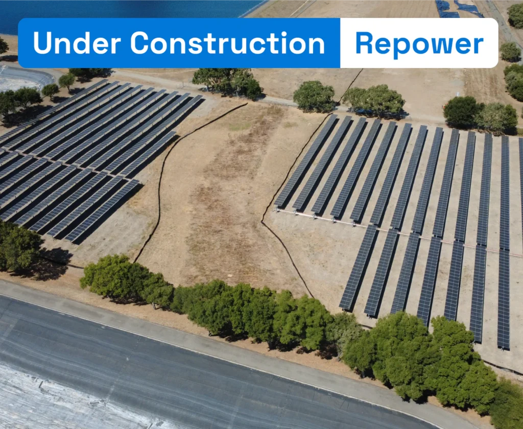 Aerial view of a solar panel array repowering project under construction in Sonoma County next to water reservoirs.